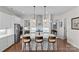 Open kitchen features stainless appliances, a large island with bar stool seating, and stylish modern lighting at 14531 Crosswater Ln, Charlotte, NC 28278