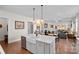 Open-concept kitchen featuring stainless steel appliances and an island with a large farmhouse sink and modern faucet at 14531 Crosswater Ln, Charlotte, NC 28278