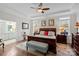 Comfortable main bedroom featuring hardwood floors, tray ceilings, and ensuite bathroom at 14531 Crosswater Ln, Charlotte, NC 28278