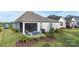 The covered patio boasts cozy blue seating, a grill, and manicured landscaping to give a relaxing outdoor space at 14531 Crosswater Ln, Charlotte, NC 28278