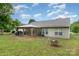 Backyard featuring a covered patio, well-manicured lawn and a fire pit ready for outdoor entertaining at 1533 Moss Creek Dr, Harrisburg, NC 28075