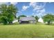 A spacious, well-maintained backyard with a covered patio and ample green space surrounded by mature trees at 1533 Moss Creek Dr, Harrisburg, NC 28075