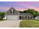 Charming gray home featuring a two-car garage and a well-manicured front lawn at 1533 Moss Creek Dr, Harrisburg, NC 28075