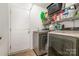 Functional laundry room with modern washer and dryer, wire shelving, and a convenient access door at 1533 Moss Creek Dr, Harrisburg, NC 28075