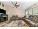 Relaxing living room featuring hardwood floors, ceiling fan, and comfortable reclining sofas at 1533 Moss Creek Dr, Harrisburg, NC 28075