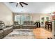 Comfortable living room with hardwood floors, ceiling fan, and reclining sofa seating at 1533 Moss Creek Dr, Harrisburg, NC 28075