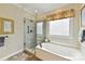 Well-lit primary bathroom featuring a soaking tub and a glass walk-in shower at 15929 Northstone Dr, Huntersville, NC 28078