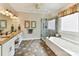 Bright primary bathroom featuring double vanities, a tub, and a walk-in shower at 15929 Northstone Dr, Huntersville, NC 28078
