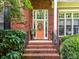 Inviting front entrance featuring a brick stairway, decorative wreath, and meticulously maintained landscaping at 15929 Northstone Dr, Huntersville, NC 28078