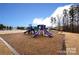 Community playground featuring three purple slides and a green climbing structure at 15929 Northstone Dr, Huntersville, NC 28078