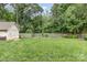 A spacious backyard featuring a shed, lush lawn, garden bed, and wood privacy fence at 1621 Brookdale Ave, Charlotte, NC 28210