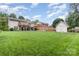 A large backyard featuring a manicured lawn, privacy fence, and spacious deck with an entertainment area at 1621 Brookdale Ave, Charlotte, NC 28210