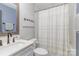 Bathroom with white tile, shower with curtain, vanity and black fixtures at 1621 Brookdale Ave, Charlotte, NC 28210