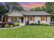 Lovely home boasts a green lawn, neat garden beds and classic architecture and covered front porch at 1621 Brookdale Ave, Charlotte, NC 28210