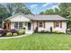 Charming single story home with manicured lawn, tidy landscaping, and decorative, rustic orange window shutters at 1621 Brookdale Ave, Charlotte, NC 28210