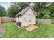 Backyard shed with painted white finish, double doors, ramp, and wood storage bin at 1621 Brookdale Ave, Charlotte, NC 28210
