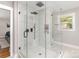 Bathroom shower featuring glass enclosure, shower head and herringbone tile at 1621 Brookdale Ave, Charlotte, NC 28210