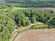 Aerial shot of property featuring multiple structures, open fields, and abundant trees at 169 Wilcox Karriker Ln, Statesville, NC 28625
