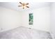 Carpeted bedroom featuring a ceiling fan and a large window at 169 Wilcox Karriker Ln, Statesville, NC 28625