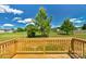 Sunny wooden deck overlooks the lush yard, trees, and charming outbuildings, perfect for outdoor relaxation at 2104 County Line Rd, Kings Mountain, NC 28086