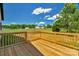 Wooden back deck offers serene views of the expansive, grassy backyard and distant neighborhood homes at 2104 County Line Rd, Kings Mountain, NC 28086