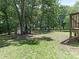 Large backyard with mature trees, a fire pit, and a storage shed at 2240 Lawton Bluff Rd, Charlotte, NC 28226