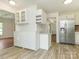 Open-concept kitchen with stainless steel refrigerator, white cabinetry, and wood-look tile flooring at 2240 Lawton Bluff Rd, Charlotte, NC 28226