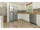 Kitchen featuring stainless steel appliances, white cabinets, and wood-look tile flooring at 2240 Lawton Bluff Rd, Charlotte, NC 28226