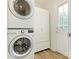 Laundry area features stacked washer/dryer unit, white cabinets, and a tile floor at 2240 Lawton Bluff Rd, Charlotte, NC 28226