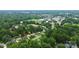 Aerial view of a neighborhood, showing a home with a red arrow pointing toward it, surrounded by lush trees at 2421 Shamrock Dr, Charlotte, NC 28205