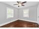 Bright bedroom with hardwood floors, ceiling fan, and two bright windows at 2421 Shamrock Dr, Charlotte, NC 28205
