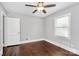 Bright, minimalist bedroom with hardwood floors, a ceiling fan, and a large window at 2421 Shamrock Dr, Charlotte, NC 28205