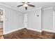 Bedroom featuring wainscoting, hardwood floors, ceiling fan, and natural light at 2421 Shamrock Dr, Charlotte, NC 28205