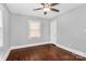 Inviting bedroom with hardwood floors, a ceiling fan, and two bright windows at 2421 Shamrock Dr, Charlotte, NC 28205
