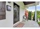 Close-up of the front porch featuring a black front door, chair, and a welcome mat at 2421 Shamrock Dr, Charlotte, NC 28205