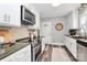 Charming kitchen featuring white cabinetry, modern stainless-steel appliances, and neutral-toned backsplash at 2421 Shamrock Dr, Charlotte, NC 28205