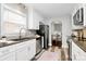 Efficient kitchen with white cabinets, modern appliances, and a view into the dining area at 2421 Shamrock Dr, Charlotte, NC 28205