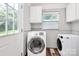 Functional laundry room with washer, dryer, and storage cabinets at 2421 Shamrock Dr, Charlotte, NC 28205