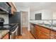 Kitchen featuring stainless steel appliances, wood cabinets, and a view to an adjacent bathroom at 2512 Cranbrook Ln # 9, Charlotte, NC 28207