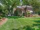 Backyard view featuring an outdoor kitchen and lush lawn, framed by mature trees at 2516 Selwyn Ave, Charlotte, NC 28209