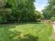 Spacious backyard with lush green lawn and mature trees at 2516 Selwyn Ave, Charlotte, NC 28209