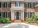 View of the front entrance with columns, a dark-colored door, and brick stairs with potted plants at 2516 Selwyn Ave, Charlotte, NC 28209