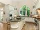 Bright kitchen featuring white cabinetry, granite countertops, a large island, and arched window at 2516 Selwyn Ave, Charlotte, NC 28209