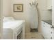 Functional laundry room with white washer, dryer, built-in ironing board, and storage cabinets at 2516 Selwyn Ave, Charlotte, NC 28209