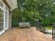 Cozy brick patio with bench, iron railing, and verdant landscaping at 2516 Selwyn Ave, Charlotte, NC 28209