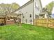 Spacious backyard featuring a deck, lush green lawn, wooden fence, and a cozy fire pit at 2518 Pinckney Ave, Charlotte, NC 28205