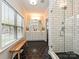 Bright bathroom features a glass shower, double vanity, hexagon tile floor and a window seat with natural light at 2518 Pinckney Ave, Charlotte, NC 28205