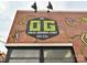 Brick building featuring 'The OG' brewery sign with colorful design and artistic details, promoting a unique local business at 2518 Pinckney Ave, Charlotte, NC 28205