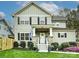 Traditional two-story home with green siding, black shutters, stone porch supports, and fresh landscaping at 2518 Pinckney Ave, Charlotte, NC 28205
