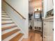 Hallway with wood stairs and flooring, leading to a bathroom with a vanity and toilet at 2518 Pinckney Ave, Charlotte, NC 28205
